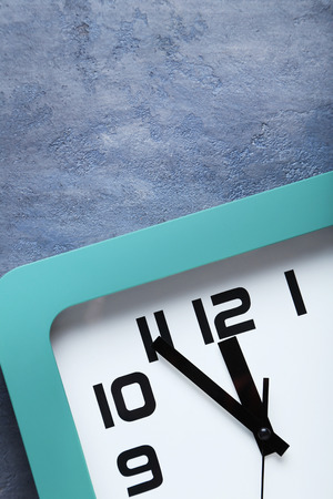 Green clock on a grey wooden table