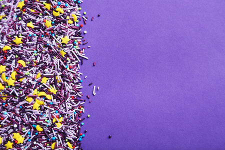 Colorful sprinkles on the purple backgroundの写真素材