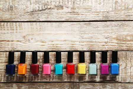 Bottles of nail polish on a grey wooden tableの写真素材