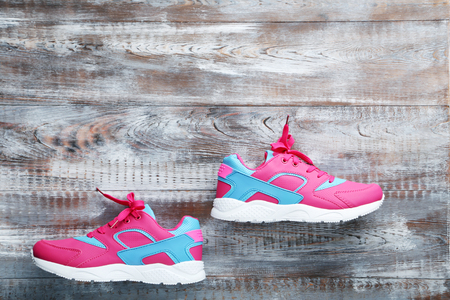 Pink sport shoes on grey wooden tableの写真素材