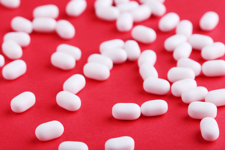 White candies gum on red backgroundの写真素材