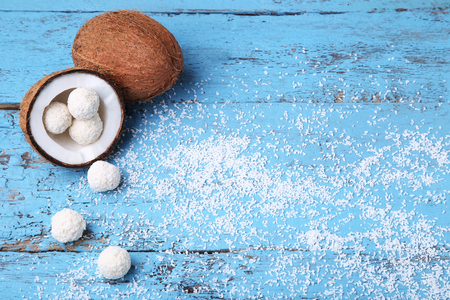 Coconuts with candies on blue wooden tableの写真素材
