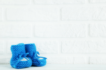 Baby's bootees on the brick wall backgroundの写真素材