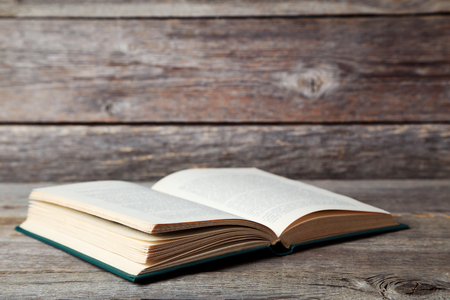 Open old book on grey wooden tableの写真素材