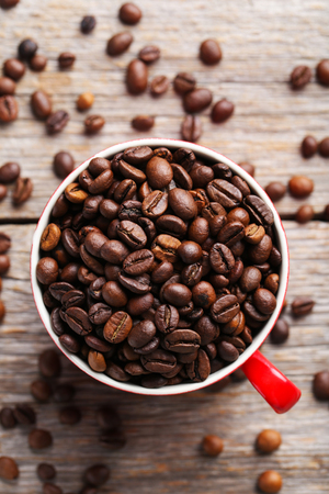 Roasted coffee beans in cup on a grey wooden tableの写真素材