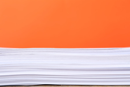Stack of papers on orange backgroundの写真素材