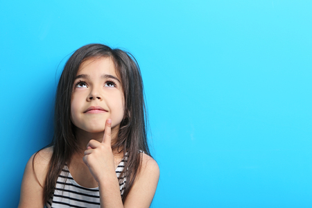 Beautiful little girl in dress on blue backgroundの写真素材