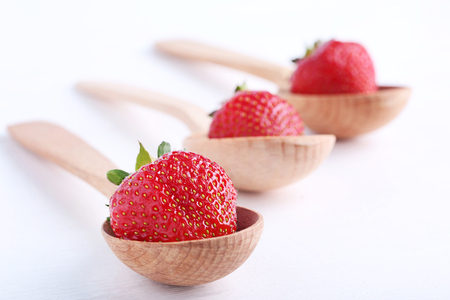 Fresh strawberries in spoon on white wooden tableの写真素材