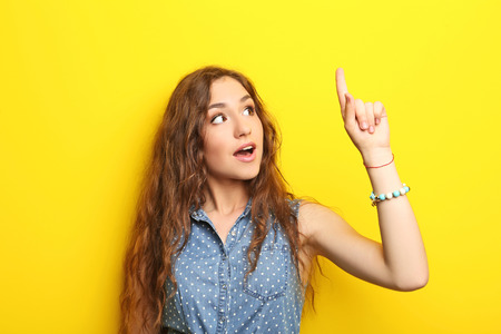 Portrait of young woman on yellow backgroundの写真素材