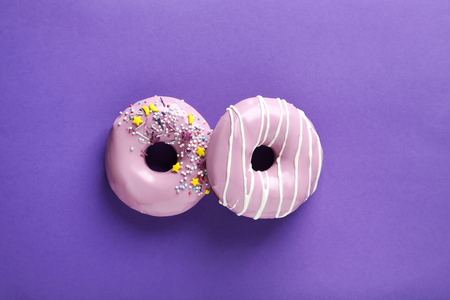 Tasty donuts with sprinkles on paper backgroundの写真素材
