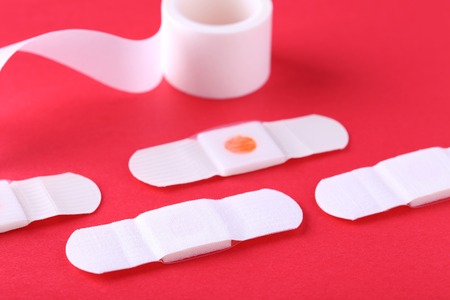 Medical plasters on red backgroundの写真素材
