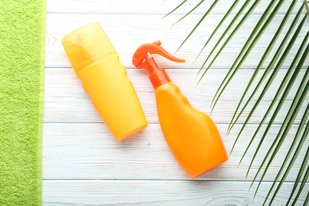 Sunscreen with towel on white wooden tableの写真素材