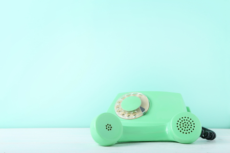 Green retro telephone on white wooden tableの写真素材