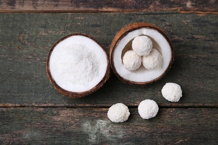Coconuts with candies on grey wooden table