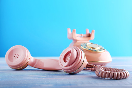 Pink retro telephone on blue wooden tableの写真素材