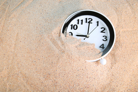 Black clock in beach sand