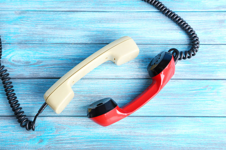 Telephone handsets on blue wooden tableの写真素材