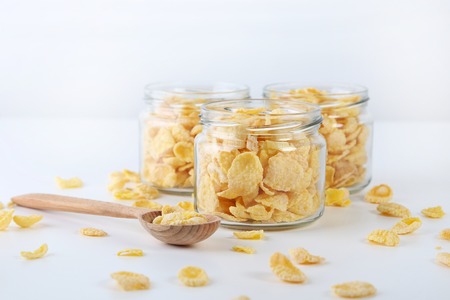 Cornflakes in glass jar on a white background