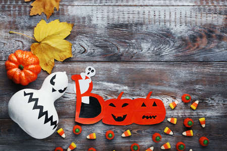 Halloween candies with pumpkin on brown wooden tableの写真素材