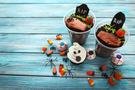 Halloween cupcake with candies on blue wooden tableの写真素材