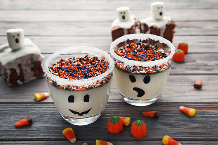 Halloween jelly in glasses with sprinkles and candies on wooden tableの写真素材