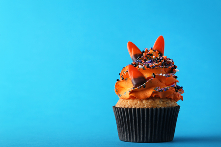 Halloween cupcake with sprinkles and candies on blue backgroundの写真素材