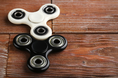 Fidget spinner toys on brown wooden tableの写真素材
