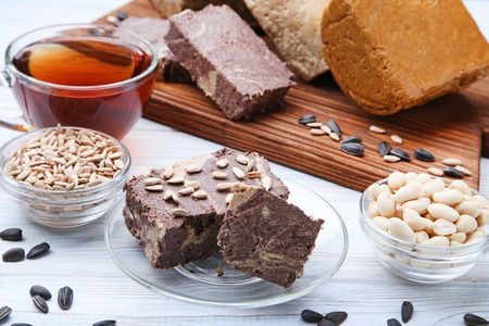 Tasty halva with peanuts and sunflowers seeds on wooden tableの写真素材