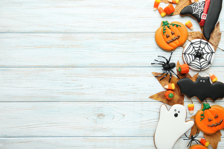 Halloween gingerbread cookies with candies on white wooden tableの写真素材