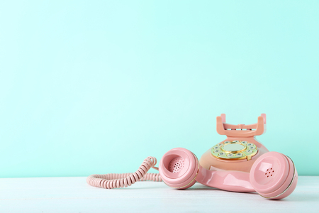 Pink retro telephone on white wooden tableの写真素材