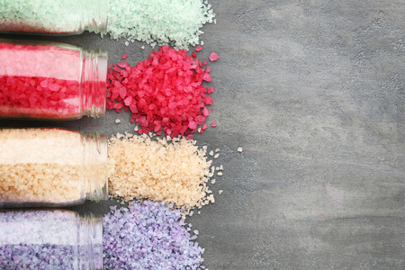 Colourful sea salt in bottles on grey wooden tableの写真素材