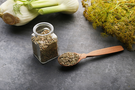 Fennel seeds in glass jar and spoon on grey backgroundの写真素材