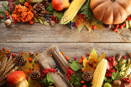 Autumn leafs with berries and vegetables on grey wooden tableの写真素材