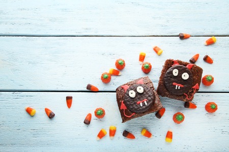 Fresh halloween cookies with candies on wooden tableの写真素材