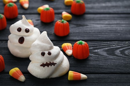 Halloween meringue with candies on black wooden tableの写真素材
