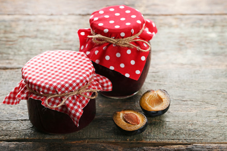 Plum jam in jars on grey wooden tableの写真素材