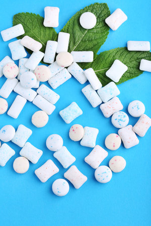 Chewing gums with mint leafs on blue background