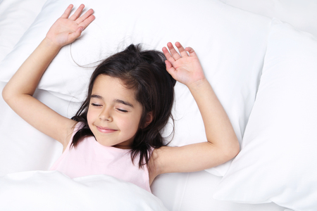 Beautiful little girl sleeping in white bed