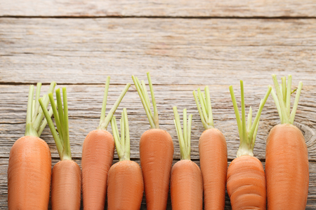 Fresh and ripe carrots on wooden tableの写真素材