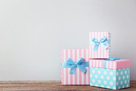 Gift boxes with ribbon on grey wooden table