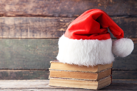Red santa hat with old books on grey wooden tableの写真素材