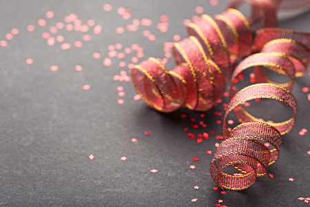 Red ribbons with confetti on black backgroundの写真素材