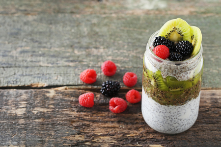 Chia pudding with berries in bottle on wooden tableの写真素材