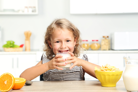 Little girl eating cornflakes with milkの写真素材