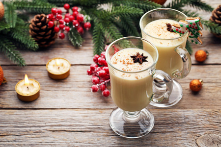 Eggnog in glasses with star anise on wooden tableの写真素材