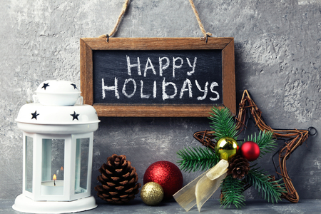 Inscription Happy Holiday on wooden frame with christmas decorations and candlestickの写真素材