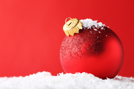 Red christmas bauble on white snowの写真素材