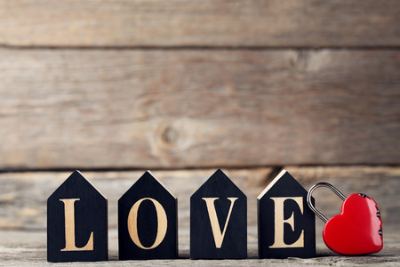 Inscription Love with red heart on grey wooden tableの写真素材