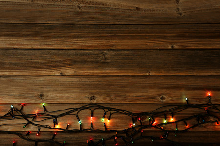 Christmas garland lights on brown wooden tableの写真素材