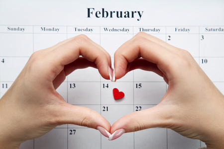 Hands in shape of heart above february calendarの写真素材